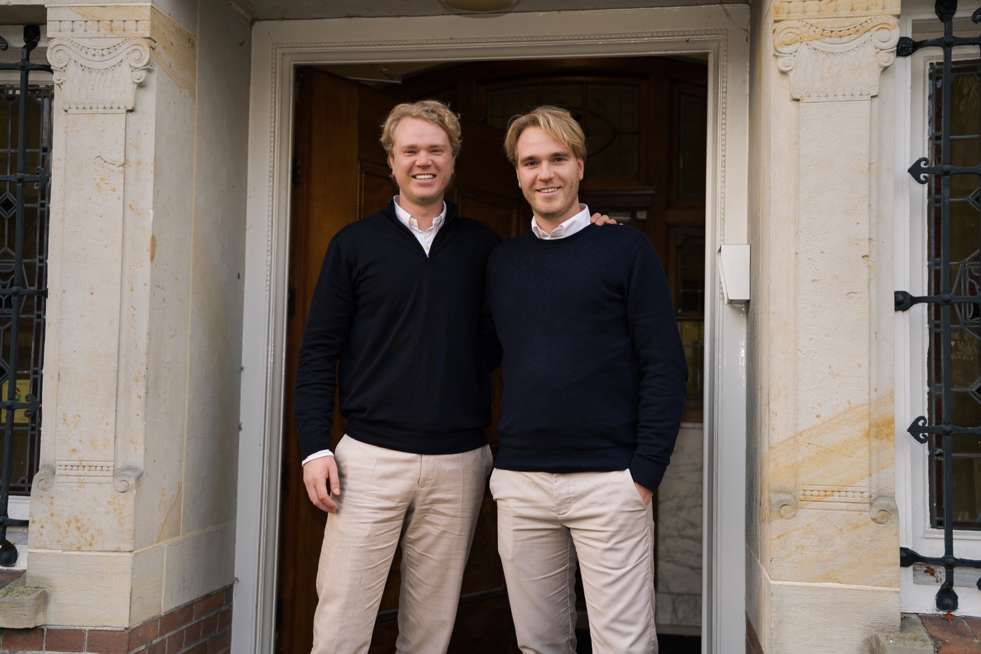 Jurriaan Monincx en Matthijs Monincx samen voor de ingang van een gebouw